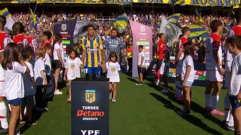 Estudiantes y un pasillo de espaldas que representa a los hinchas del fútbol